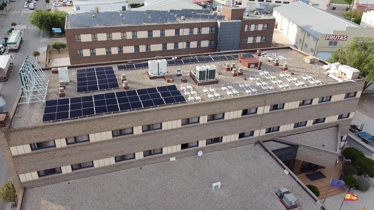 Vista aérea de la cubierta del Hotel Ciudad de Alcañiz con los módulos fotovoltaicos montados en filas sobre estructura lastrada